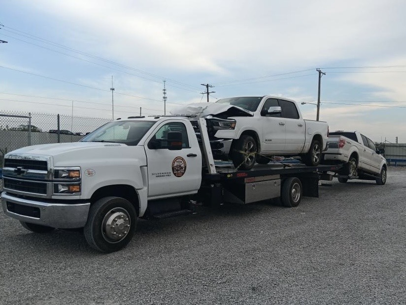 Something Moore flatbed truck recovering a damaged pickup after an accident